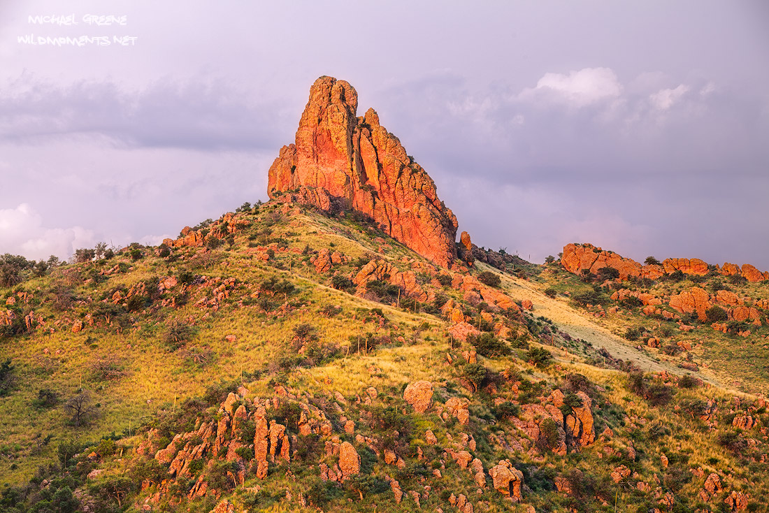 Monsoon light at sunset reflecting on a striking rock monument as seen from Ruby Road near Nogales, Arizona and the international...
