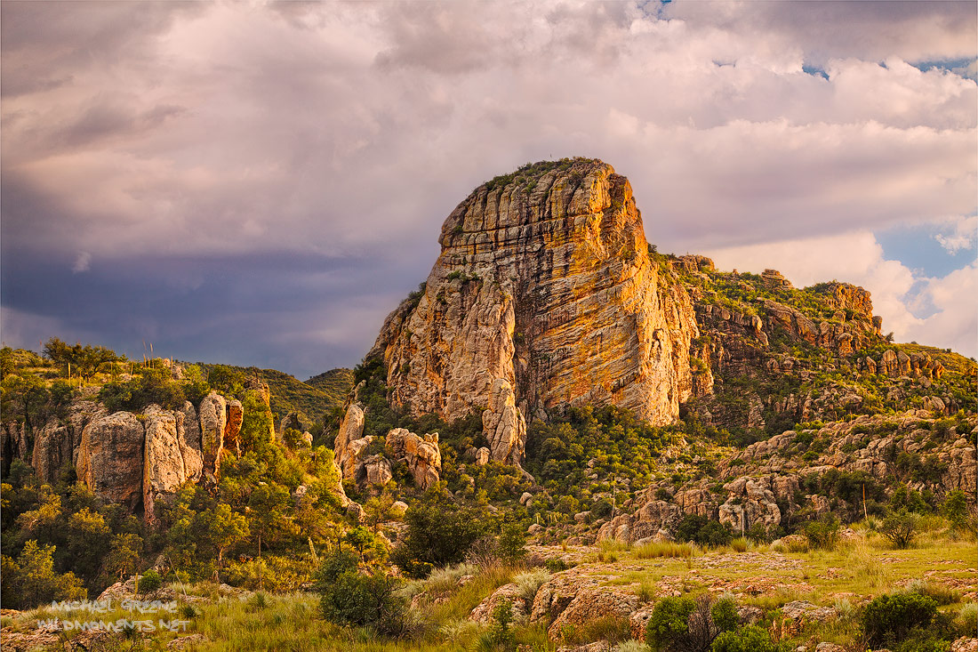 Monsoon light at sunset reflecting on a striking rock monument as seen from Ruby Road near Nogales, Arizona and the international...