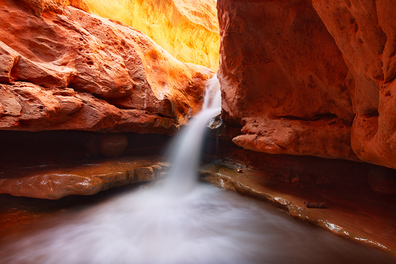 A symetrical waterfall in the heart of a semi-technical slot canyon in Utah shows off its best colors.