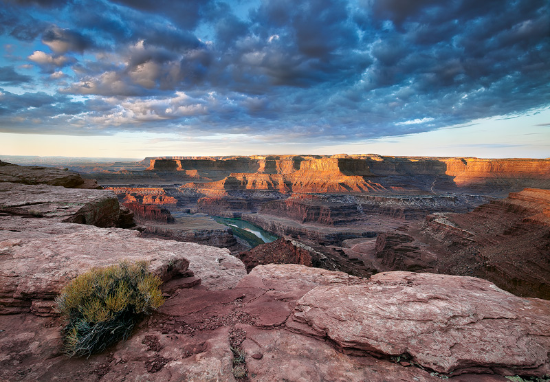 An almost unbelievable scene of clouds and light spill onto the gaping overlook of the meadenering Colorado River near Dead Horse...