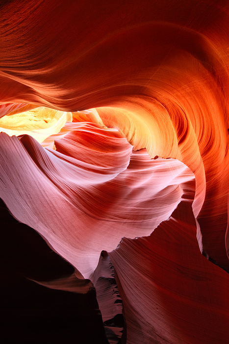 A dark, twisted passage of sandstone in Antelope Canyon leads the viewer up through the light. This abstract scene is open to...